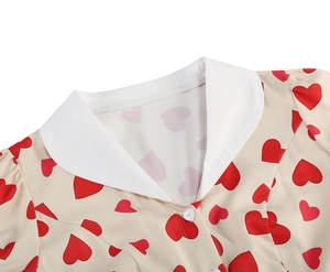 Detailed close-up of white Peter Pan collar and heart buttons on printed dress