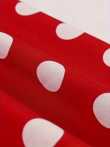 Close-up of red and white polka dot fabric texture showing smooth weave and soft folds