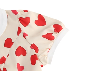 Detail of red heart print dress featuring a white Peter Pan collar and short sleeves