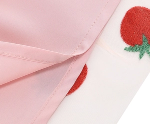 Close-up of pink fabric with white mesh and sequin cherry embroidery detail