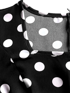Close-up of square neckline and side zipper on a black vintage polka dot dress