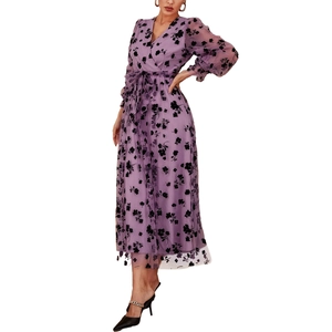 Détail d'une robe fleurie violette à col en V avec manches longues et ceinture à nouer