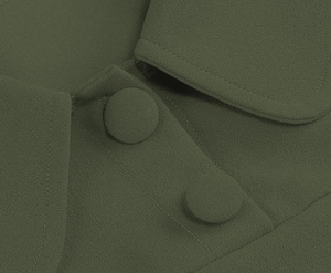 Detail of olive green dress showing high-quality fabric texture and covered buttons