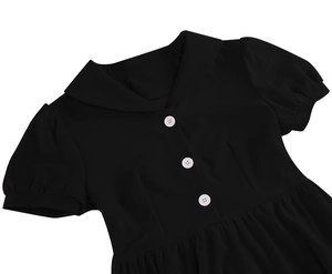 Detail of vintage black dress featuring a contrast white lapel collar and button accents