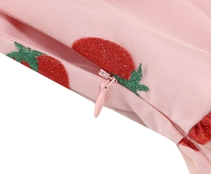 Close-up of pink mesh dress with red glitter strawberry embroidery and hidden zipper