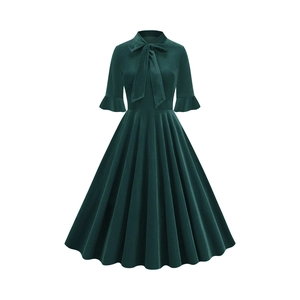 Detail of dark green velvet dress featuring bow neckline and elegant ruffle cuffs