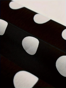 Macro shot of high-quality black and white polka dot fabric with detailed knit texture