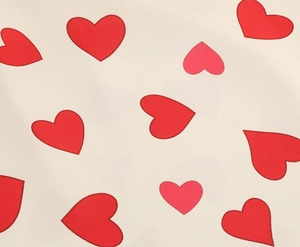 Close-up of vintage short sleeve dress fabric featuring romantic red heart prints
