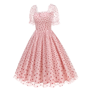 Dettaglio dell'abito in tulle rosa con cuori rossi e maniche corte a sbuffo
