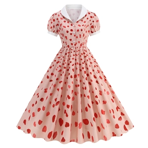 Detail of pink retro A-line dress featuring red heart print and white pointed collar