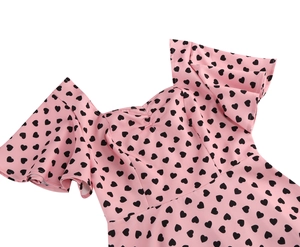 Close-up of the sweetheart neckline and flutter sleeves with a black heart print pattern