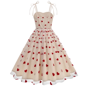 Detail view showing the back of the beige tulle dress with red heart embroidery and bow straps