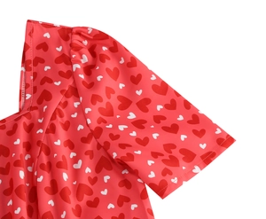Détail du motif à cœurs et des coutures plissées à l'épaule sur la robe rouge élégante