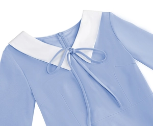 Detail of baby blue dress featuring a white Peter Pan collar and delicate bow tie neckline