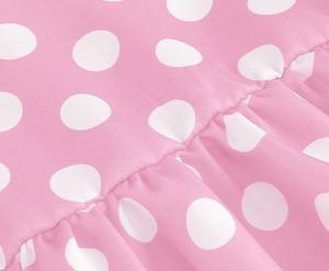 Detail of pink fabric with white polka dots featuring pleated sewing craft and soft texture