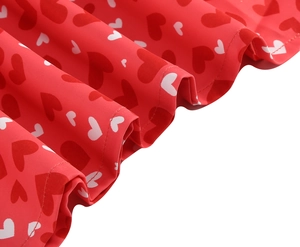 Gros plan du tissu à imprimé cœurs rouges avec plis et détails de couture soignés