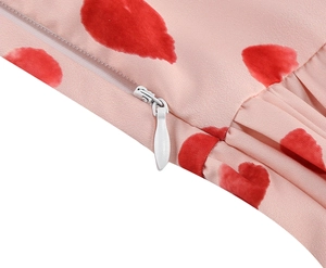 Close-up of invisible zipper and red heart print on light pink chiffon dress fabric
