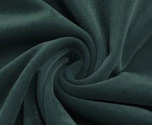 Macro shot of dark green velvet fabric texture showing smooth luster and draped material