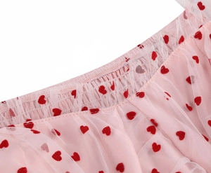 Dettaglio della gonna in tulle rosa chiaro con cuori rossi e vita elastica pieghettata