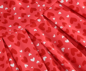 Détail du tissu plissé rouge avec motifs de cœurs blancs et texture élégante