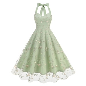 Detail of light green mesh dress with floral embroidery and elegant back bow tie