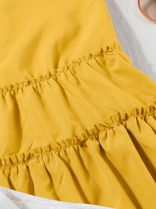Detail des gestuften Rüschensaums am ingwergelben Urlaubs-V-Ausschnitt-Trägerkleid
