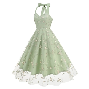 Close-up of elegant light green mesh fabric with delicate pink floral embroidery