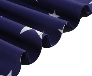 Detail shot of navy blue fabric with white star print and crisp textured pleats