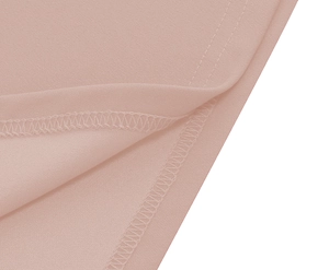 Detail of light pink dress hem showcasing double-line stitching and overlock seam quality