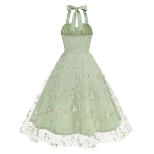 Detail of the light green halter dress featuring elegant floral embroidery and a mesh bow