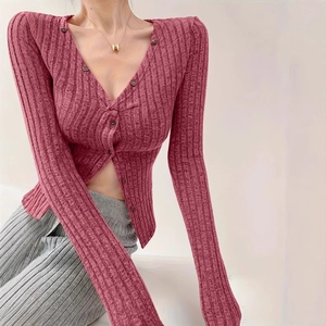Dettaglio del cardigan in maglia a coste rosa con scollo a V e chiusura con bottoni scuri