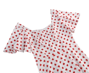 Detail of square neckline and ruffle sleeves on white dress with red heart pattern