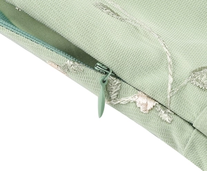 Close-up of high-quality invisible zipper on a light green floral embroidery pillow case