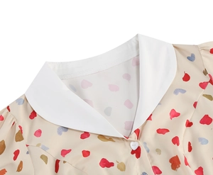 Close-up of white Peter Pan collar with heart-shaped button on a floral dress