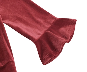 Detail of burgundy velvet dress sleeve featuring elegant ruffled cuffs and soft fabric