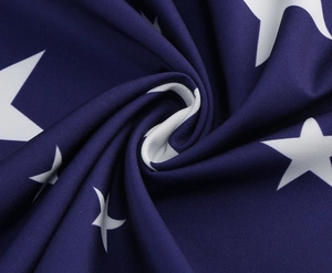 Detailed macro view of navy blue fabric with white star pattern and soft draped texture
