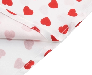 Detailed close-up showing fine stitching on the white fabric with red heart prints