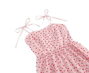 Close-up of pink heart print dress featuring delicate mesh layer and ribbon bow straps