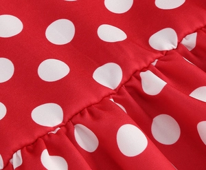 Detailed macro view of red polka dot cotton fabric with professional pleated ruffles