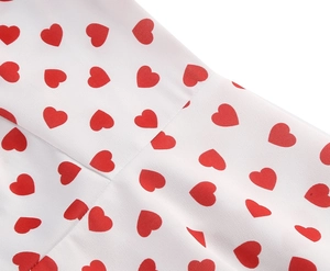 Detailed close-up of red heart patterns on white fabric with high-quality stitching