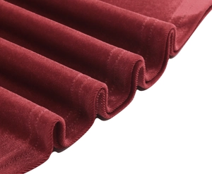 Detail of red velvet fabric texture with soft sheen and wavy stitched edge finish