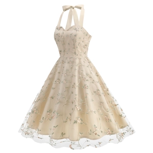 Detail of pink floral embroidery on a champagne mesh halter dress with a bow neck