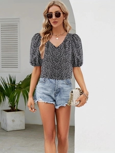 Close-up of floral V-neck puff sleeve top with light blue distressed denim shorts