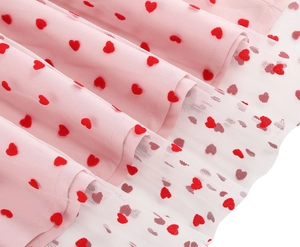 Detail view of pink multi-layer tulle skirt with vibrant red heart embroidery patterns