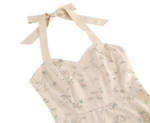 Close-up of beige mesh dress with floral embroidery and silk neck tie bow detailing