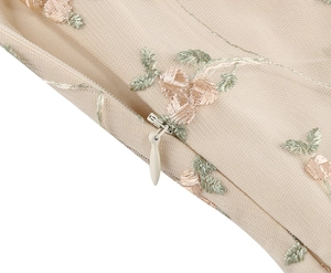 Detailed close-up of floral embroidery and invisible zipper on mesh cocktail dress