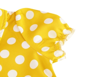 Close-up of yellow polka dot dress showing ruffle sleeve detail and neat stitching