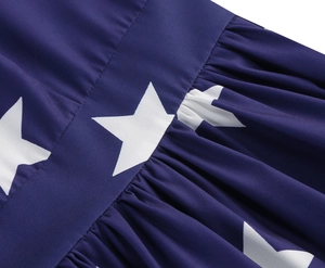 Detailed macro view of white star patterns on navy blue fabric with pleated waist seams
