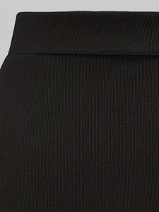 Détail du tissu côtelé noir montrant la texture verticale et la couture de taille