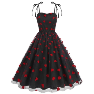 Close-up of red heart embroidery on black tulle layers and shoulder bow ribbons